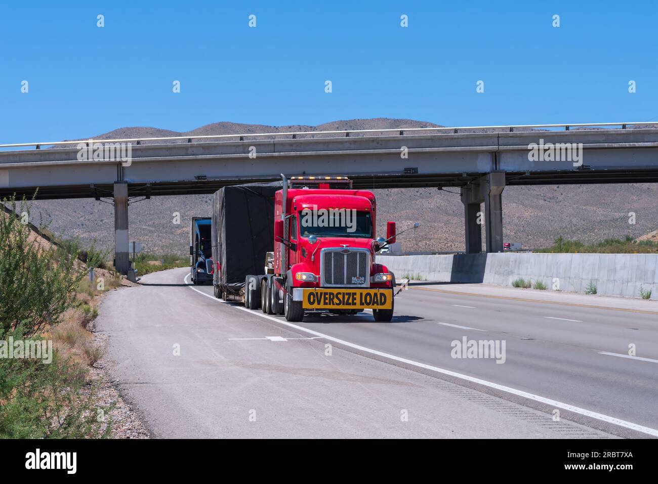 Semi-camion illustré tirant une charge surdimensionnée sur l'I-15 par une journée ensoleillée. Banque D'Images