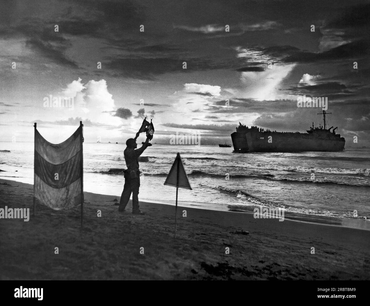 Sarmi, Nouvelle-Guinée néerlandaise, 17 mai 1944 Un coxswain des garde-côtes dirige les LSTS gardés et garnis de troupes vers leurs positions d'échouage avec des signaux sémaphores. Banque D'Images