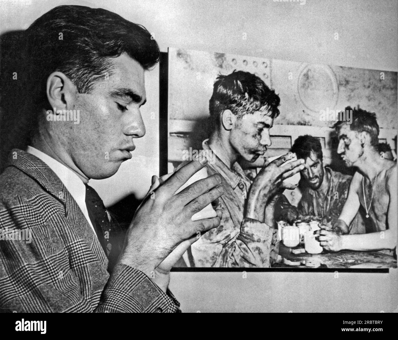 Washington, DC : Mars, 1946 récemment libéré Marine Faris Touhy frappe une pose similaire à l'image graphique de lui buvant une tasse de café et fatigué de deux jours de combats sur l'atoll d'Eniwetok en février 1944. Banque D'Images