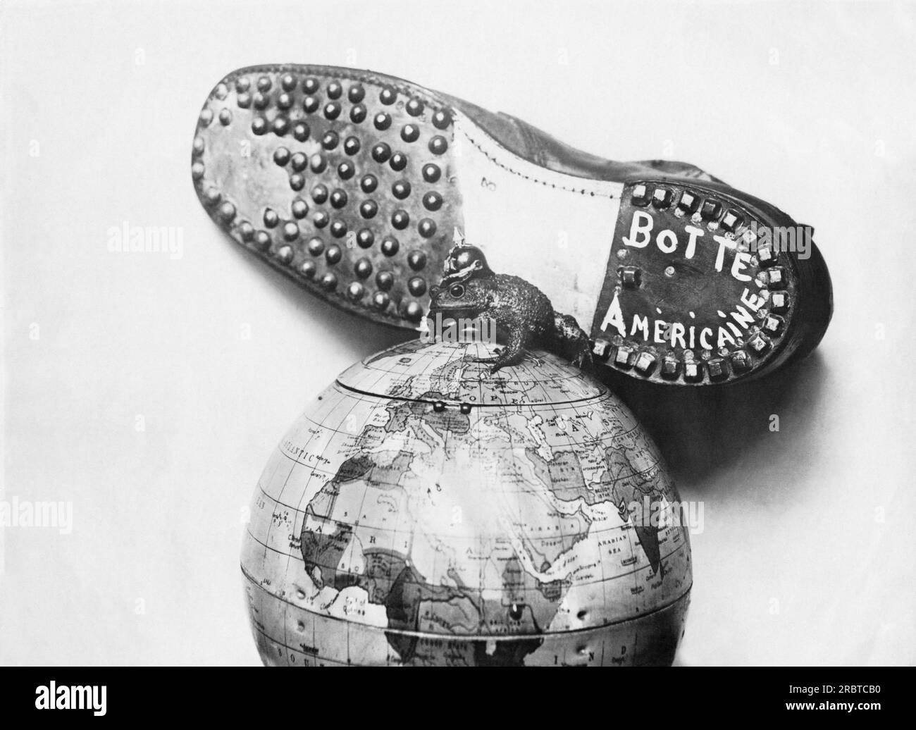États-Unis : 17 mai 1918 Un dessin animé d'une botte américaine sur le point d'écraser le Kaiser et ses satellites prussiens junker du globe. Le Kaiser est dépeint comme une grenouille géante au sommet du monde. Banque D'Images