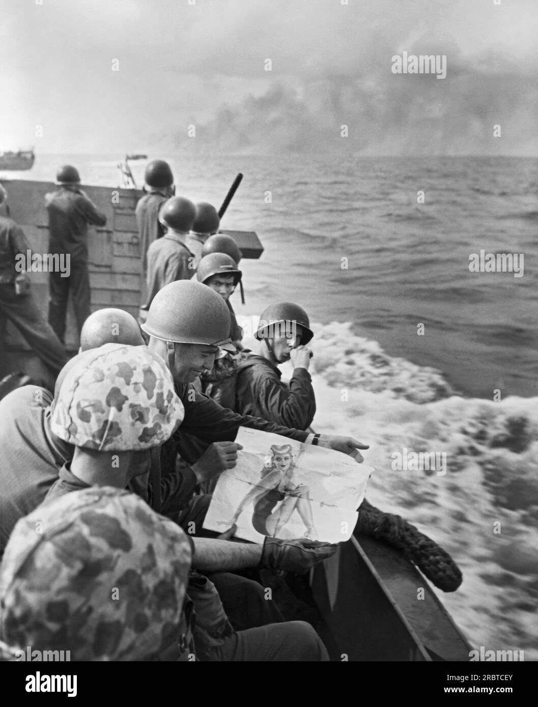 Îles Gilbert, océan Pacifique : 1943 Marines des États-Unis sur une barge de débarquement partagent l'observation d'une pin-up girl alors qu'ils approchent de l'île de Tarawa tenue par les Japonais. Banque D'Images