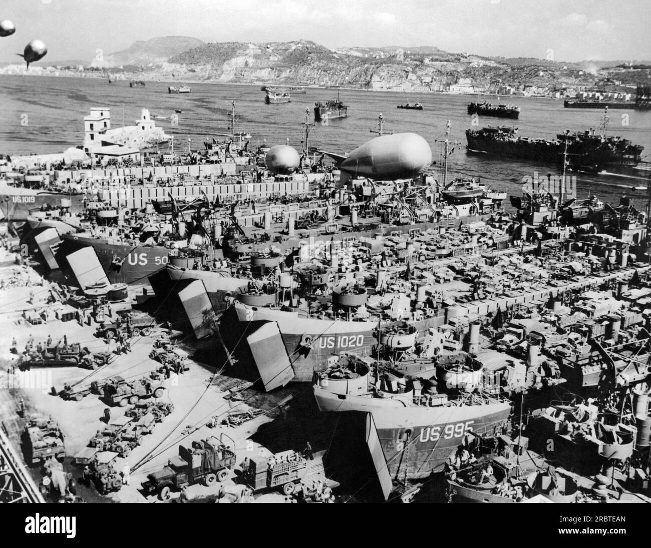 Italie : août 1944 la flottille de LSTS chargée de ravitaillement dans un port du sud de l'Italie en préparation de l'opération Dragoon, l'invasion de la France sur sa côte sud le 15 août 1944. La photo montre seulement une petite partie de la flotte. Les ballons de barrage protègent des attaques ennemies volantes à basse altitude. Banque D'Images