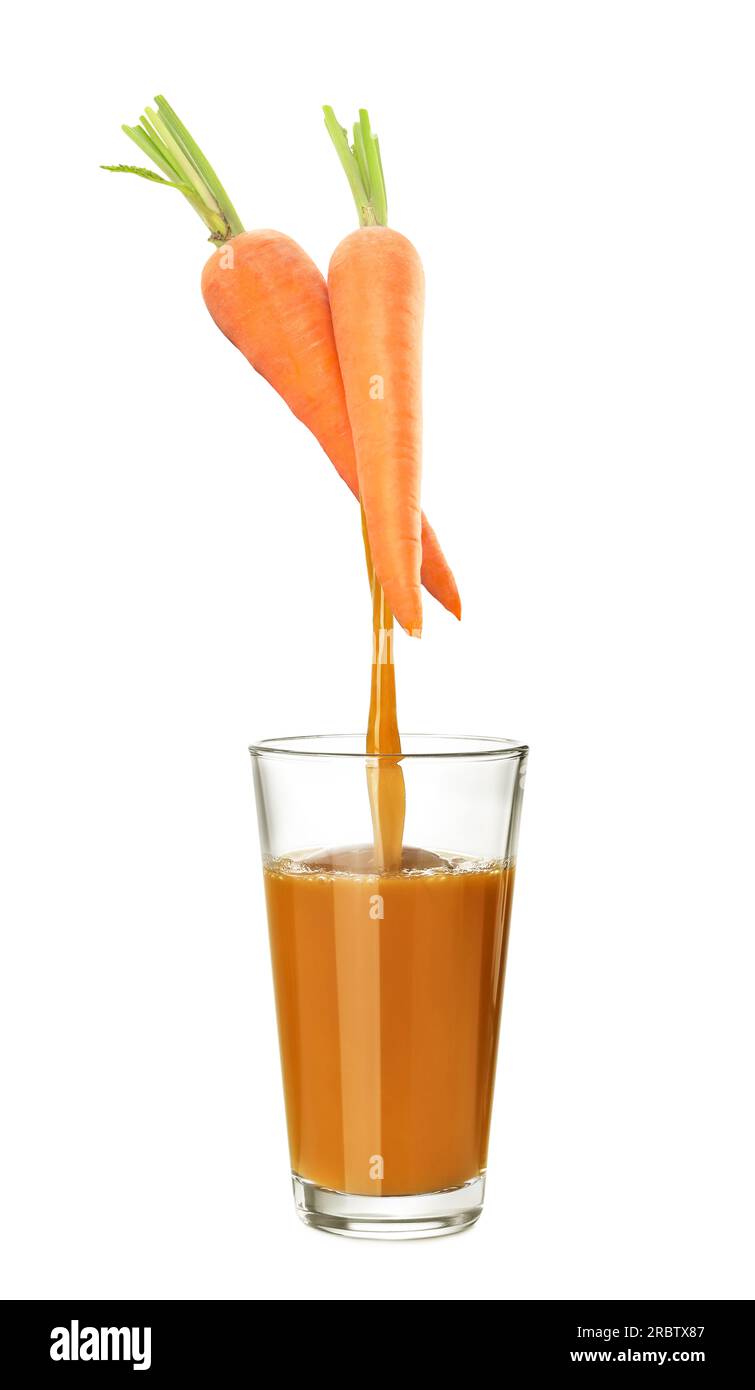 Verser le jus fraîchement pressé de carottes dans le verre sur fond blanc Banque D'Images