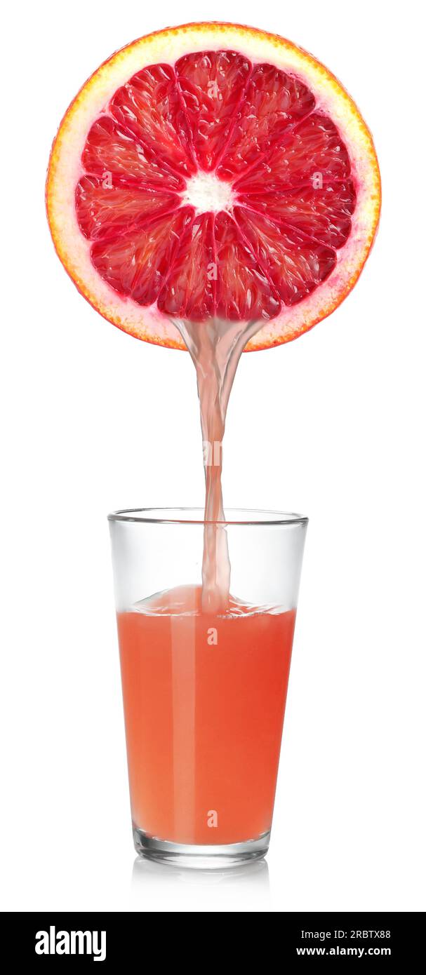 Verser le jus fraîchement pressé de pamplemousse dans le verre sur fond blanc Banque D'Images