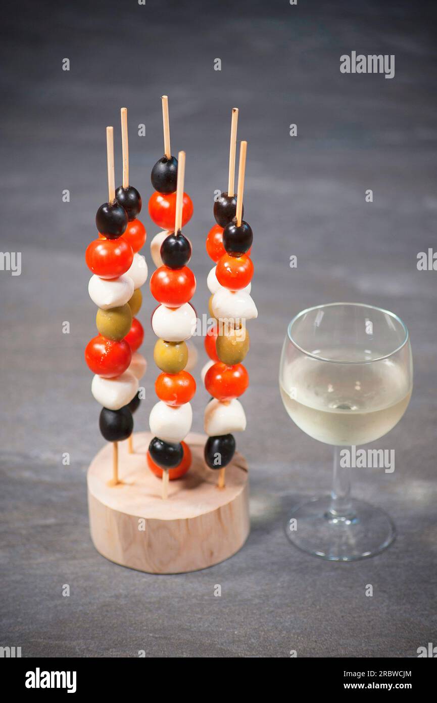 Brochettes de fromage Mozzarella, olives et tomate au vin blanc Banque D'Images