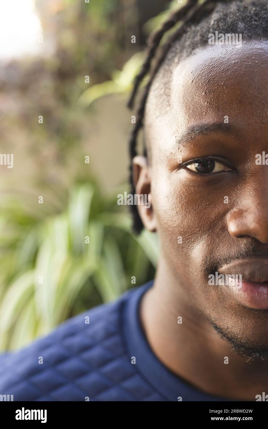 Demi-portrait d'homme afro-américain heureux avec espace de copie dans le jardin ensoleillé Banque D'Images