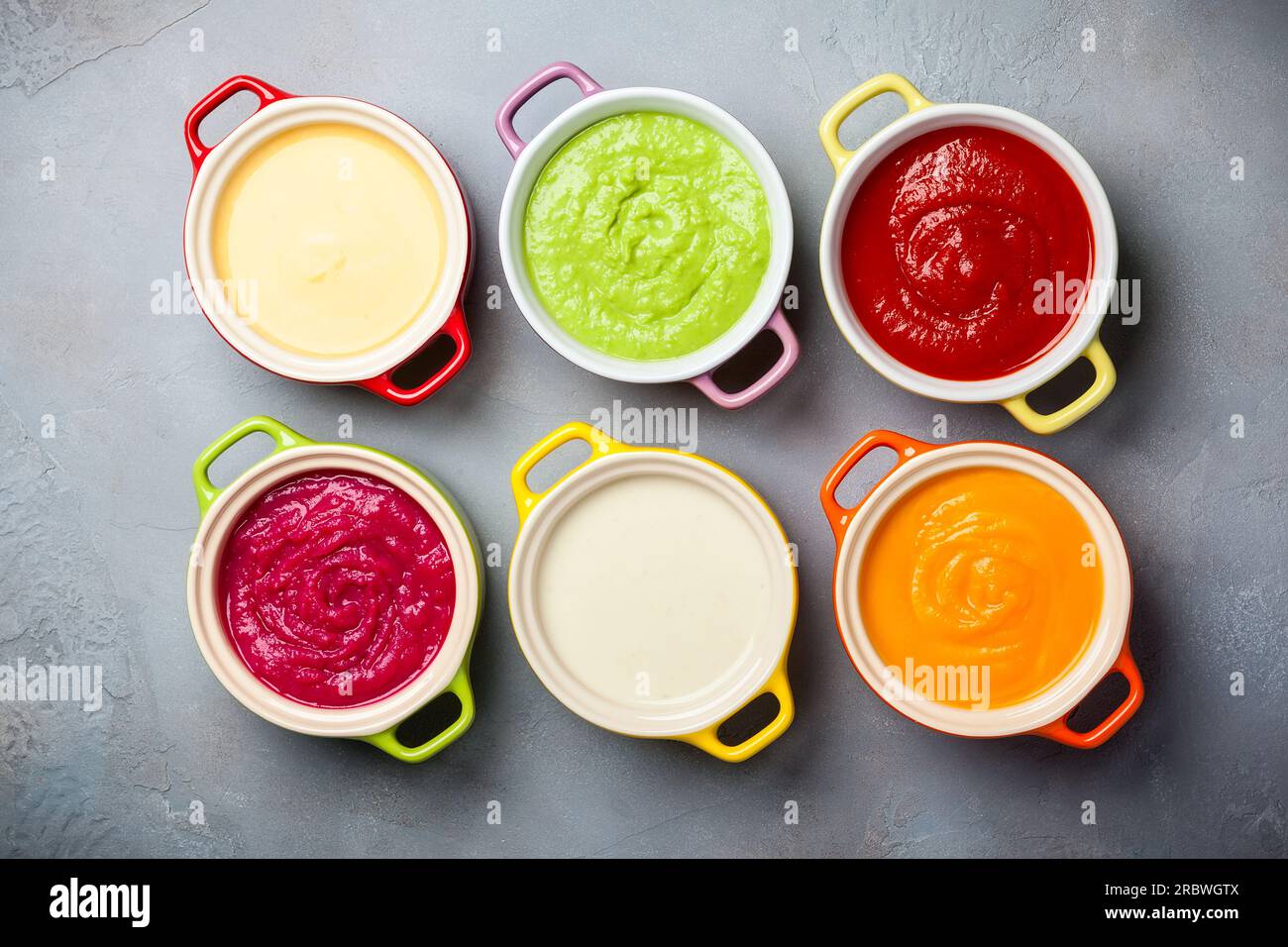 Variété de soupes à la crème de légumes colorés dans de petits pots. Vue de dessus. Concept d'alimentation saine ou de nourriture végétarienne. Banque D'Images