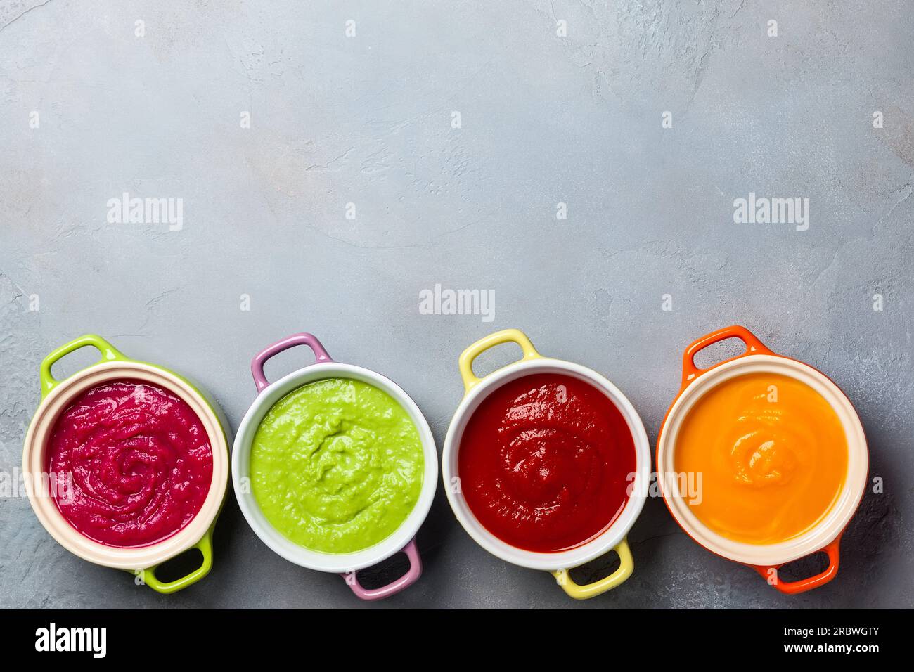 Variété de soupes à la crème de légumes colorés dans de petits pots. Vue de dessus. Concept d'alimentation saine ou de nourriture végétarienne. Banque D'Images