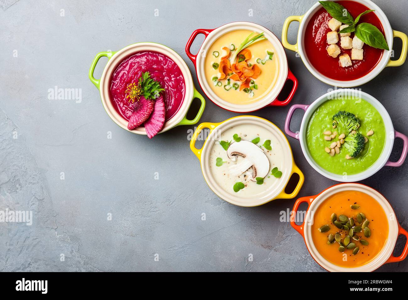 Variété de soupes à la crème de légumes colorés dans de petits pots. Vue de dessus. Concept d'alimentation saine ou de nourriture végétarienne. Banque D'Images