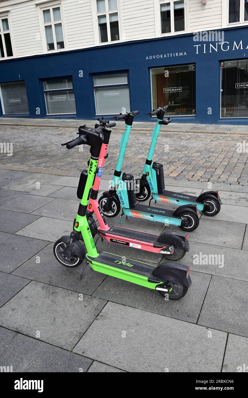 Location de scooters électriques garés sur le trottoir à Stavanger, en Norvège, en attendant leurs prochains loueurs. Banque D'Images