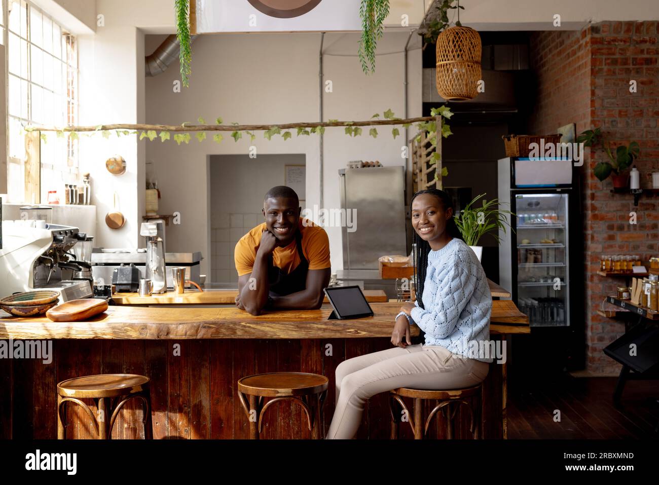 Portrait de couple afro-américain heureux de propriétaires de café avec tablette sur le comptoir Banque D'Images