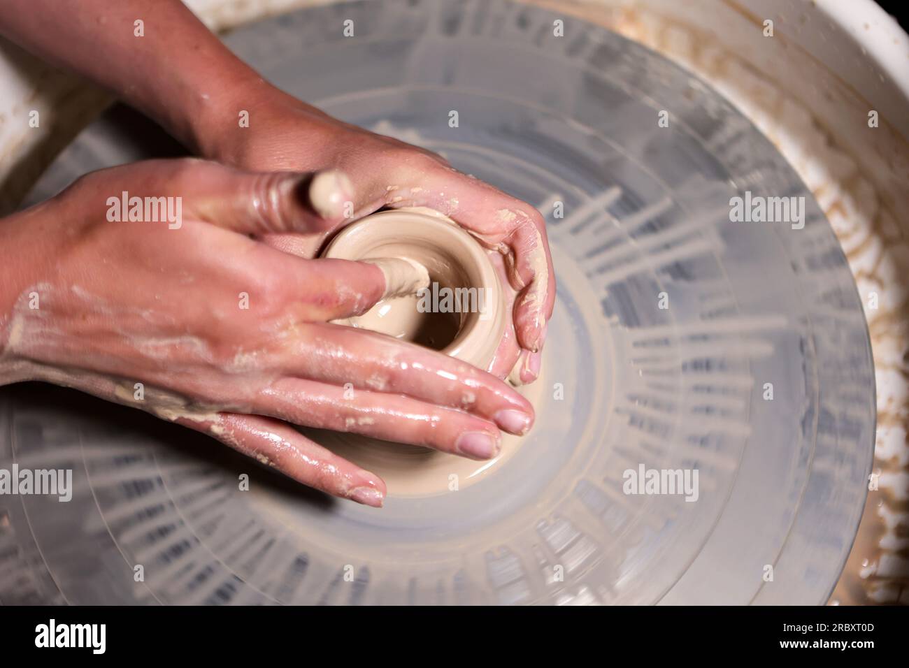 Non exclusive : RÉGION D'IVANO-FRANKIVSK, UKRAINE - 07 JUILLET 2023 - les mains des participants à une classe de maître de poterie travaillent avec de l'argile sur un potier&#x92;s. Banque D'Images