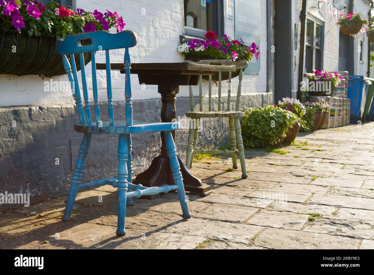 Vieilles chaises en pin peint et table en bois sur Une rue pavée à l'extérieur D'Une maison publique à Wareham Town, Dorest Royaume-Uni Banque D'Images