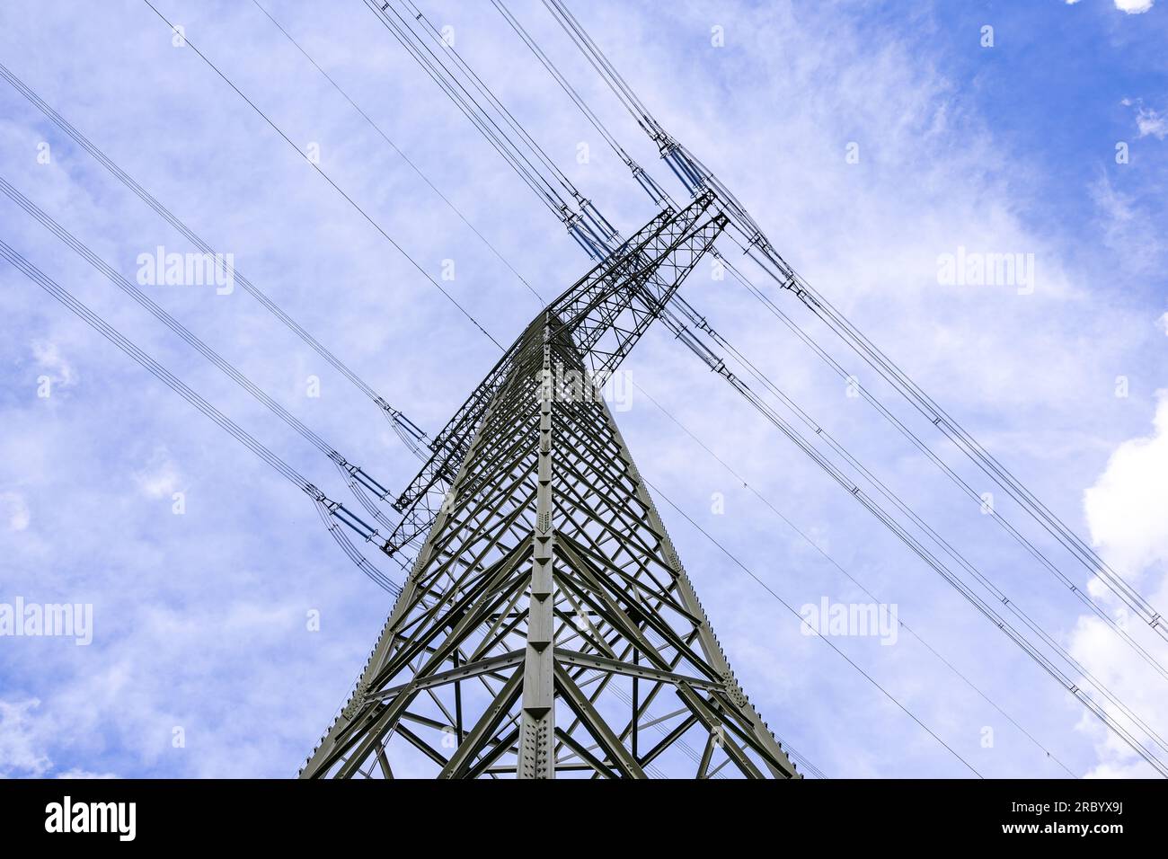Poteau électrique en acier haute tension avec lignes électriques diagonalement d'en bas contre le ciel Banque D'Images