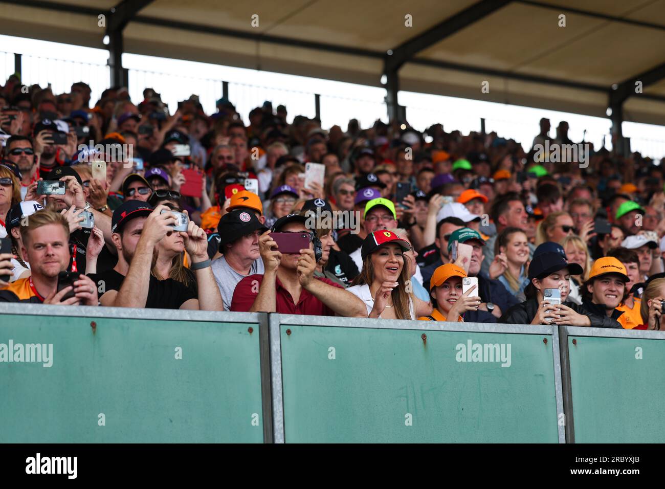 Les fans du Grand prix de Formule 1 se tiennent debout et applaudissent et applaudissent les pilotes de Grand Prix lorsqu'ils les passent et prennent également des vidéos et des photos sur le mobile Banque D'Images