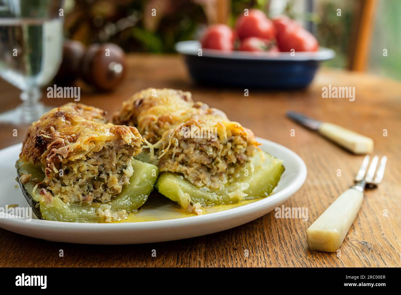 Courgettes farcies, cuites avec de la viande, des oignons, des herbes et du fromage sur la table en bois Banque D'Images