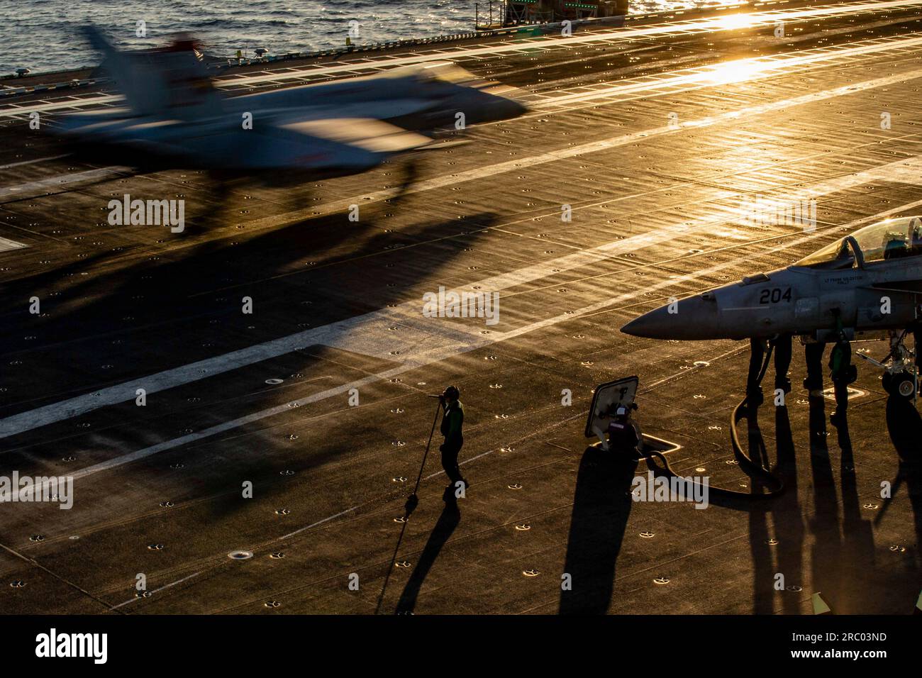 Mer Adriatique, eaux internationales. 08 juillet 2023. Mer Adriatique, eaux internationales. 08 juillet 2023. Un marin américain observe un avion de chasse Super Hornet de la Navy F/A-18E, attaché au Tomcatters of Strike Fighter Squadron 31, atterrit au coucher du soleil depuis le poste d'envol à bord du porte-avions de classe Nimitz USS Gerald R. Ford opérant sur la mer Adriatique, le 8 juillet 2023 au large des côtes albanaises. Crédit : MC2 Nolan Pennington/États-Unis Navy photo/Alamy Live News Banque D'Images