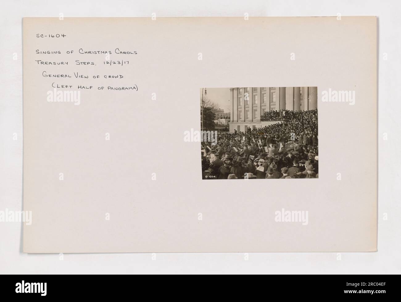 Des membres du chœur communautaire sont vus chanter des chants de Noël sur les marches de l'édifice du Trésor en décembre 2017. L'image montre une vue générale de la foule rassemblée pour l'événement. (Photographie : 111-SC-1604) Banque D'Images