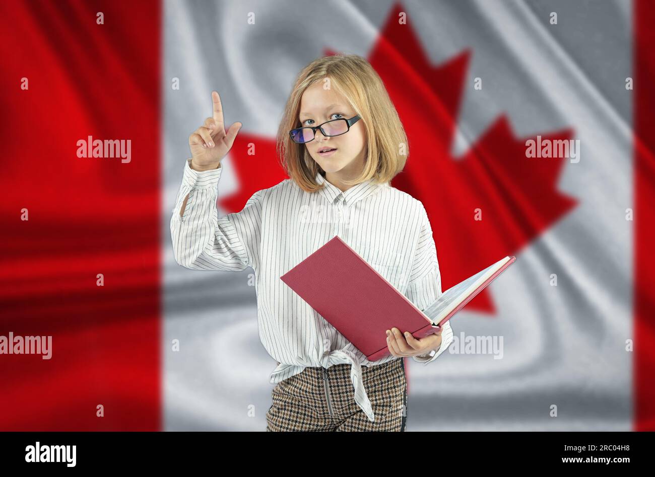 Une fille avec un livre à la main montre un geste - attention sur le fond du drapeau du Canada. Concept d'éducation. Banque D'Images