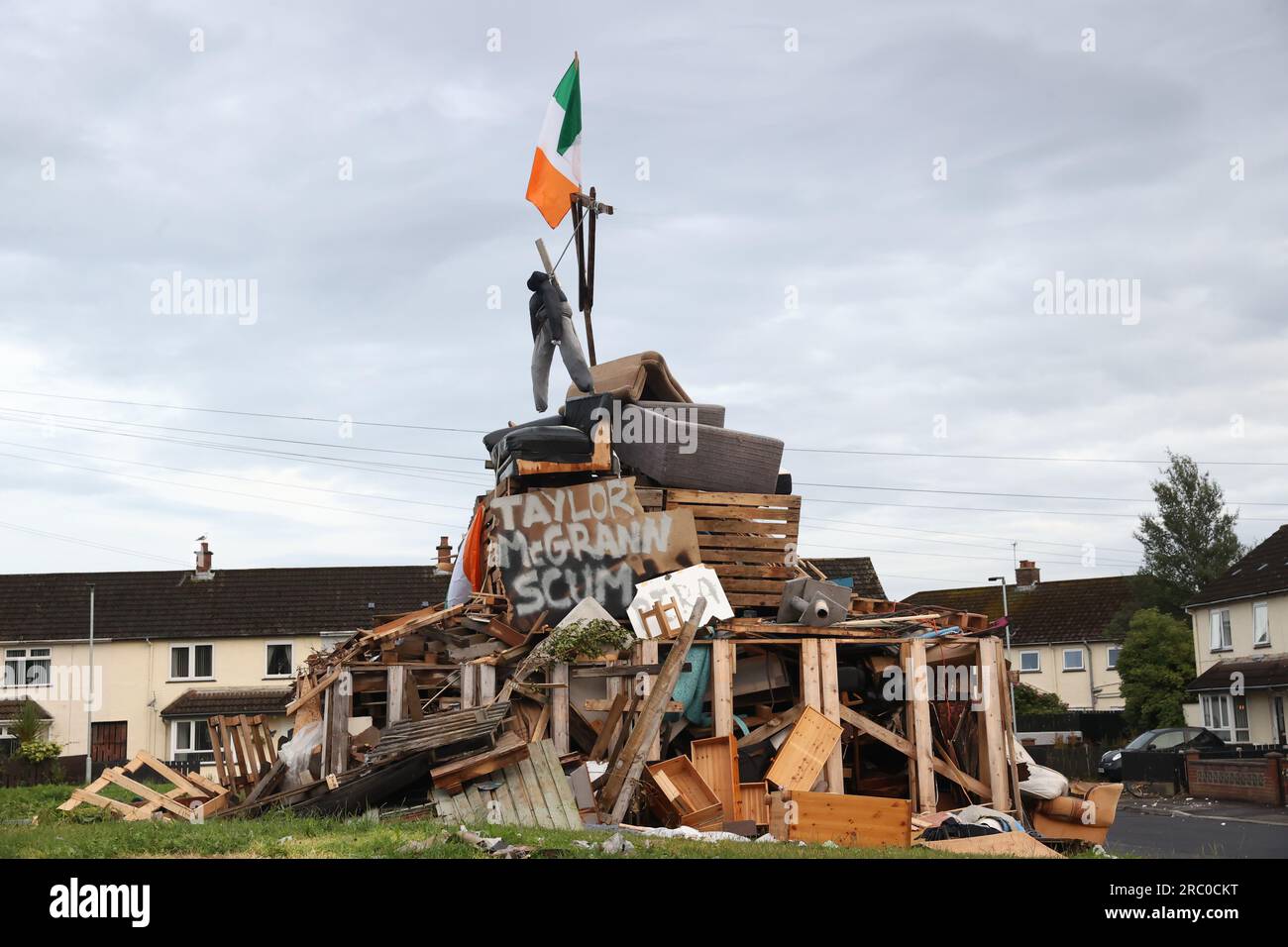 Une effigie au-dessus d'une affiche avec le nom de Taylor McGrann, le conseiller du Sinn Fein pour Antrim & Newtownabbey Borough, sur le feu de joie à Carnreagh Bend, Rathcoole, Newtownabbey, la onzième nuit pour inaugurer les douzième commémorations. Date de la photo : mardi 11 juillet 2023. Banque D'Images