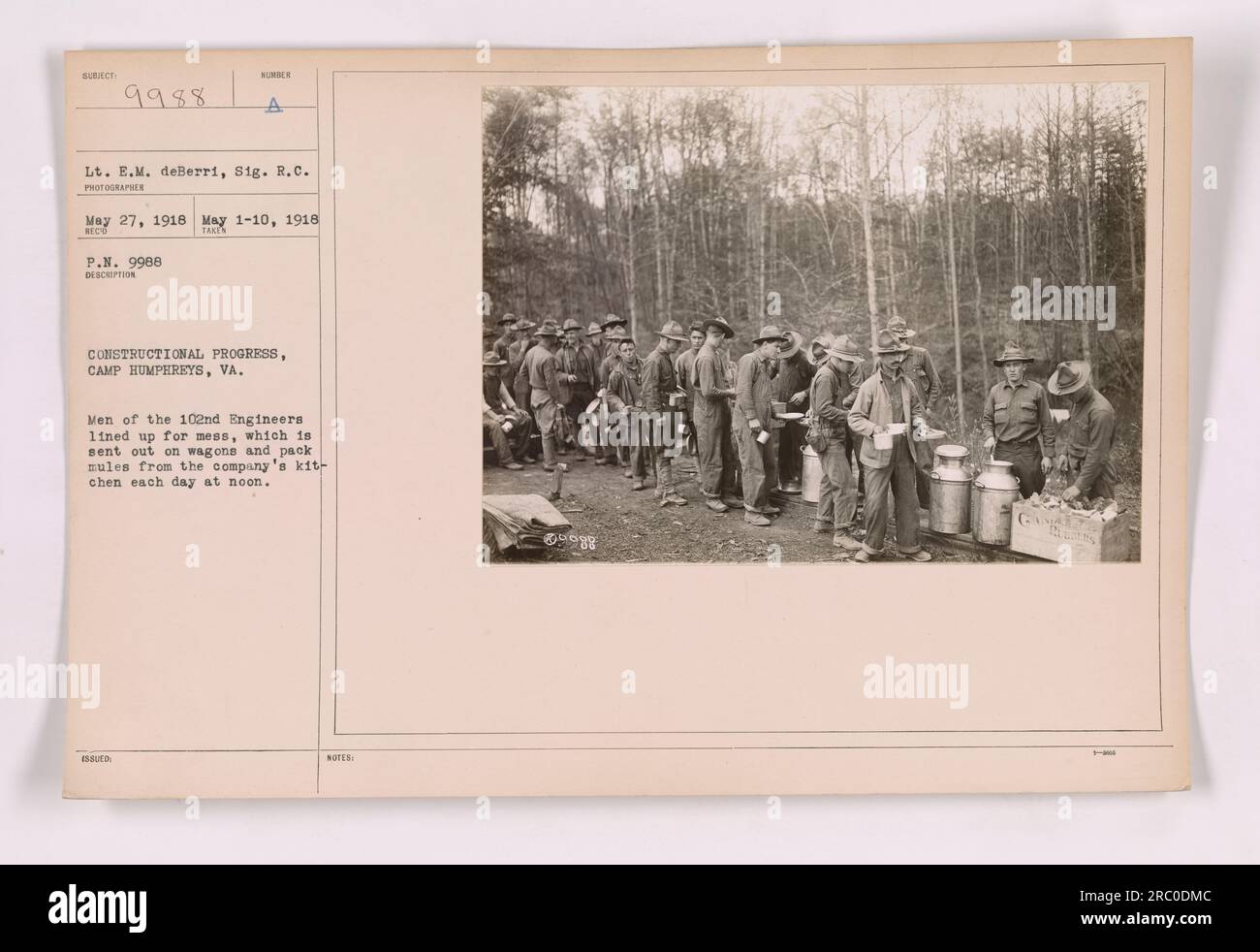 Les hommes du 102e génie à Camp Humphreys, Virginie, font la queue pour leur repas envoyé de la cuisine de la compagnie sur des wagons et des mules. Cette photographie, #111-SC-9988, a été prise par le lieutenant E.M. deBerri et SIG. R.C. le 27 mai 1918. L'image montre l'avancement de la construction au camp. Banque D'Images