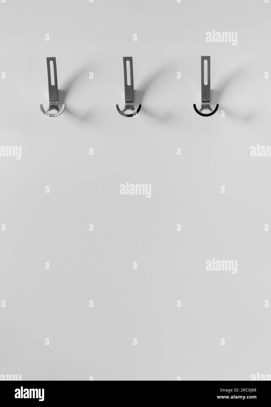 Cintre pour vêtements d'extérieur avec crochets en métal sur un mur blanc dans un intérieur moderne du couloir d'un appartement, maison. Éléments d'intérieur, design de prem Banque D'Images