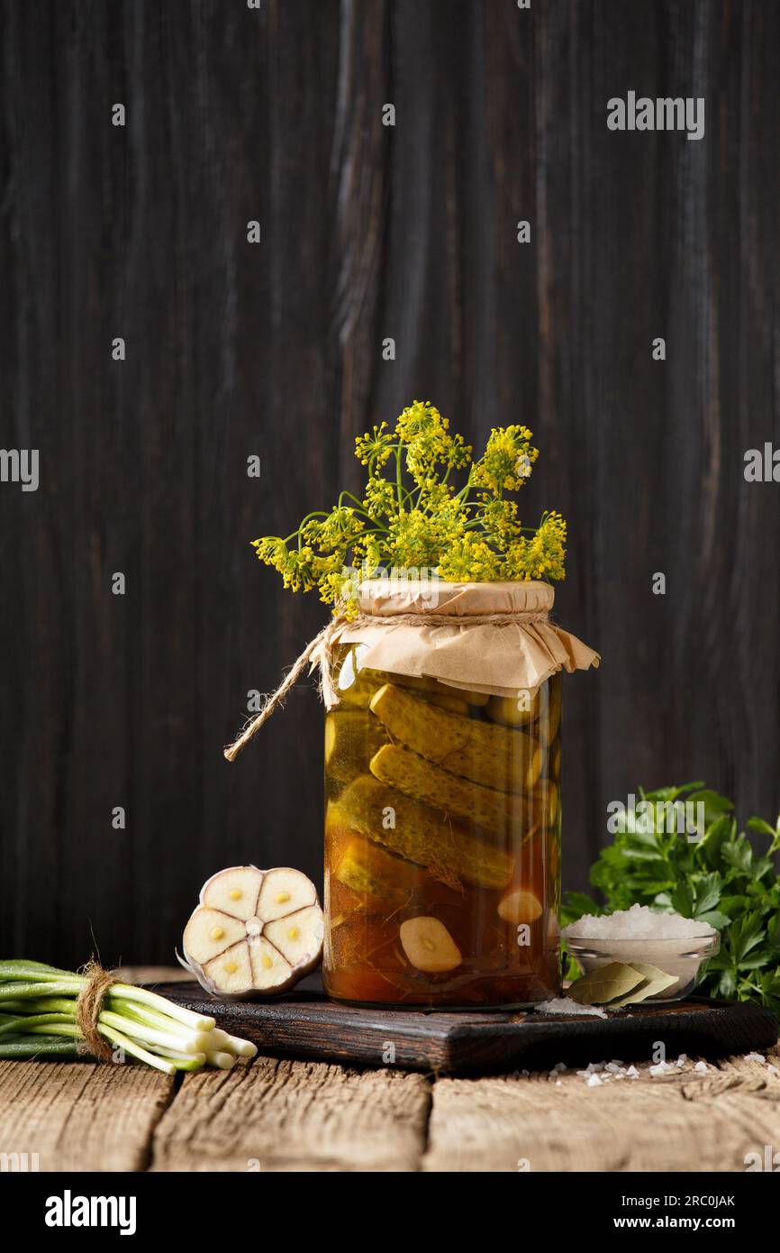 Concombres marinés dans un bocal, cornichons frais, garlicn sur un fond en bois. Poivrons, oignons et cornichons frais pour la conservation. Salade de concombre. Banque D'Images