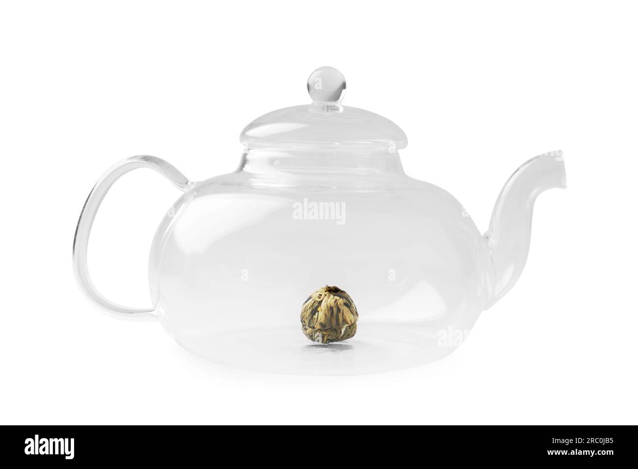 Théière transparente en verre vide et thé vert fleur tricoté sec sur fond blanc. Ustensiles pour faire du thé. Banque D'Images