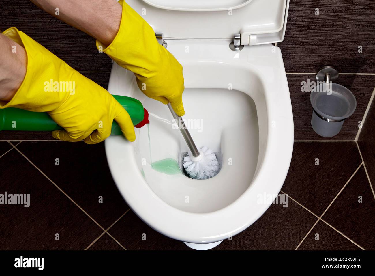 Main En Caoutchouc Jaune Gant Tient La Brosse De Toilette à L