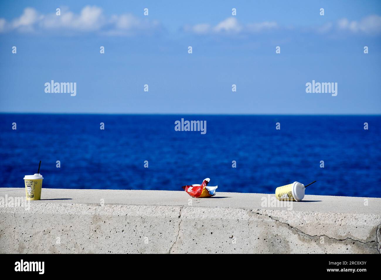 Une photographie significative de restes vides d'une matinée avec des amis au bord de la mer. Les déchets n'ont jamais été mieux, mais nettoyons la prochaine fois. Banque D'Images