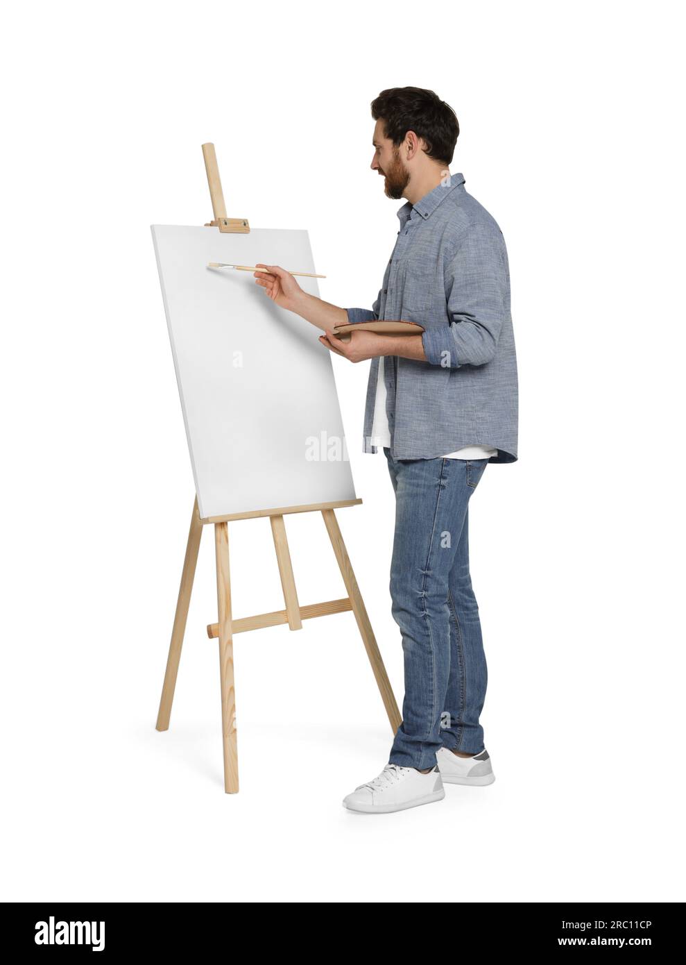 Homme avec peinture au pinceau sur fond blanc. Utilisation du chevalet pour tenir la toile Banque D'Images