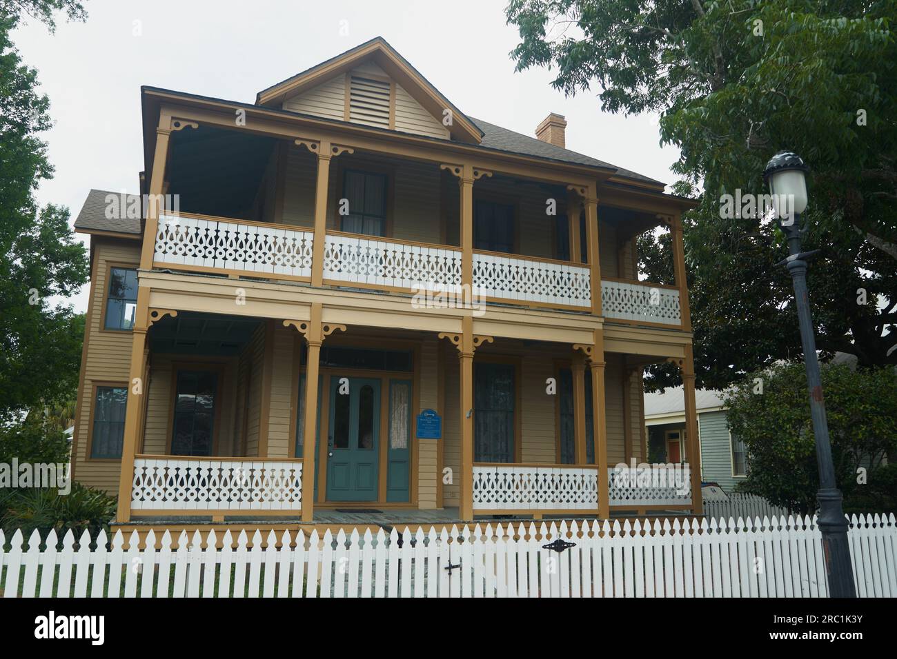 Une maison historique de style créole français avec un porche enveloppant et une clôture de piquet blanche à Pensacola, en Floride. Banque D'Images