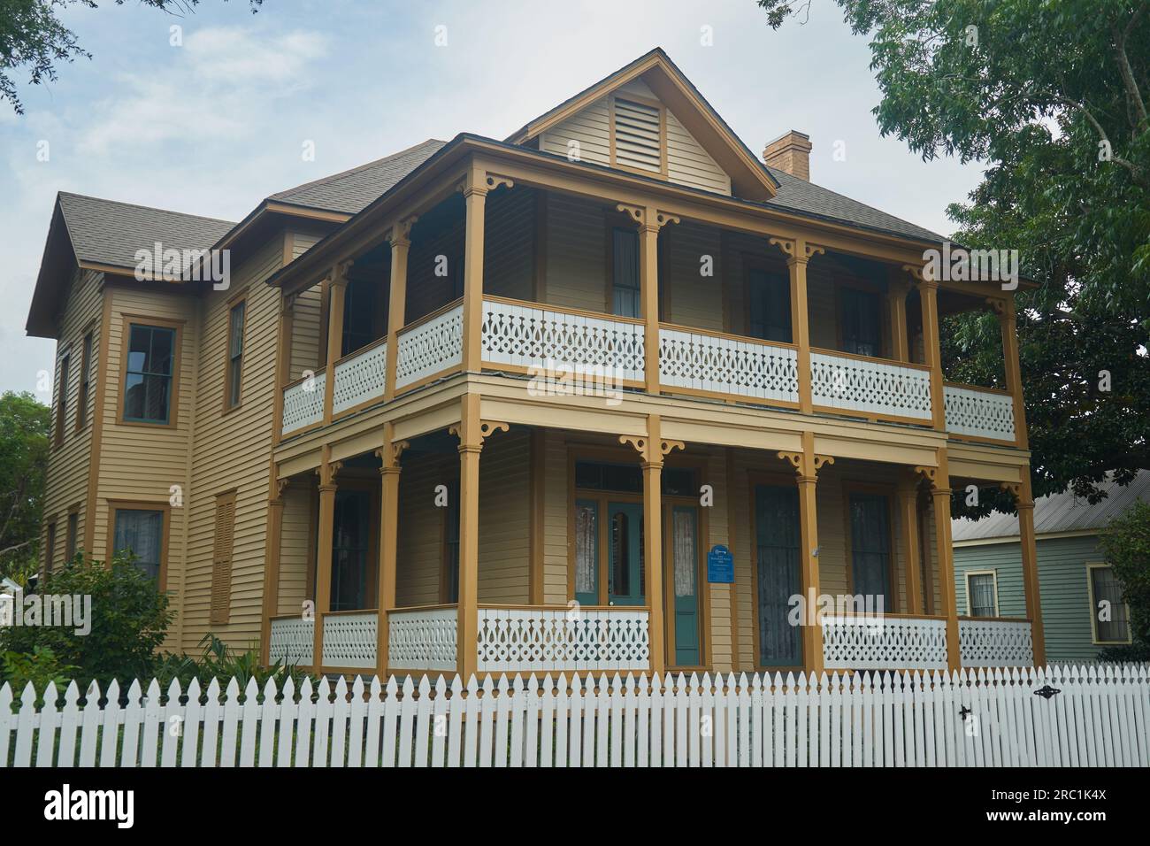 Une maison historique de style créole français avec un porche enveloppant et une clôture de piquet blanche à Pensacola, en Floride. Banque D'Images