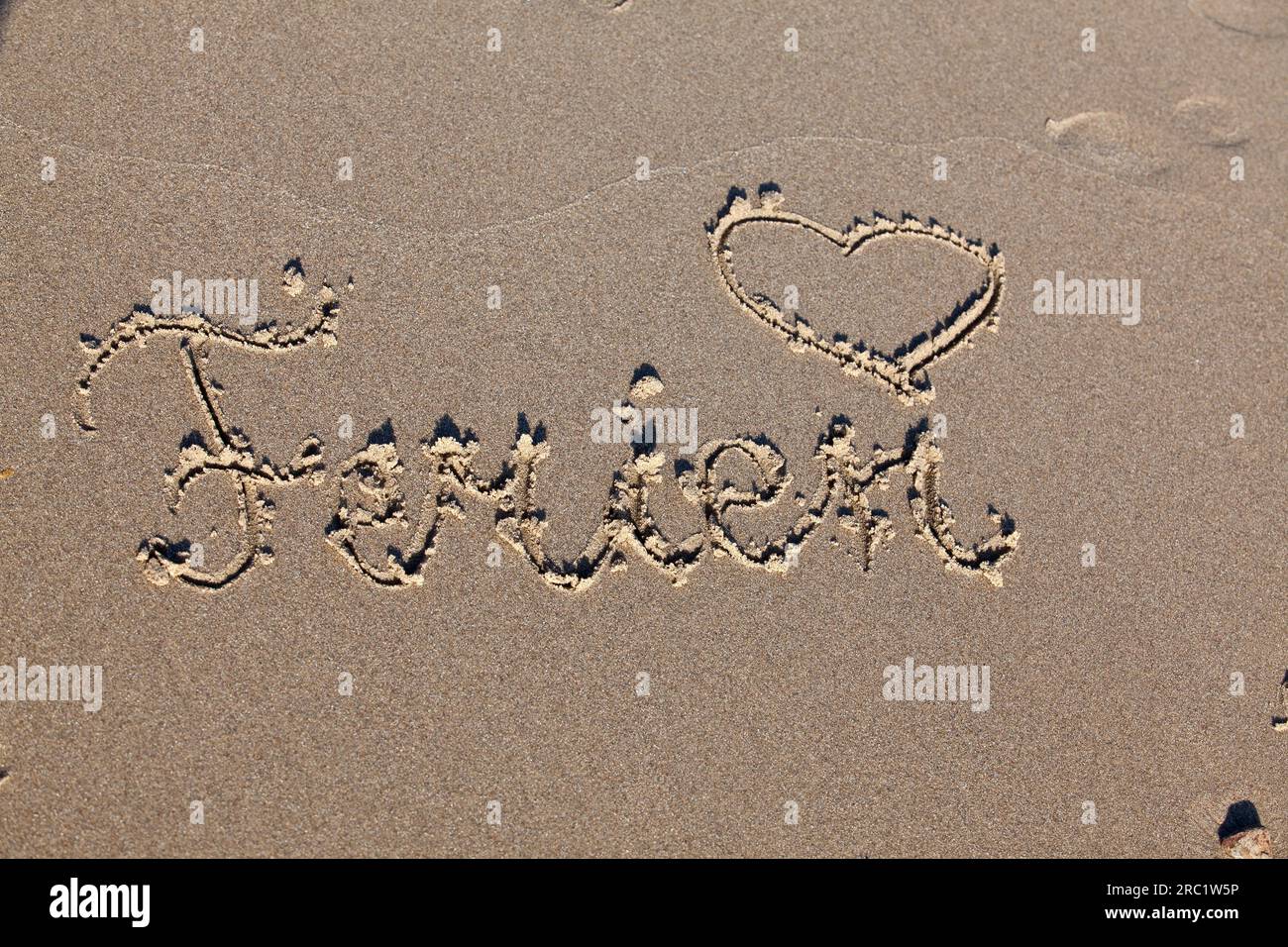 Coeur dessiné dans le sable sur la plage avec les mots vacances Banque D'Images