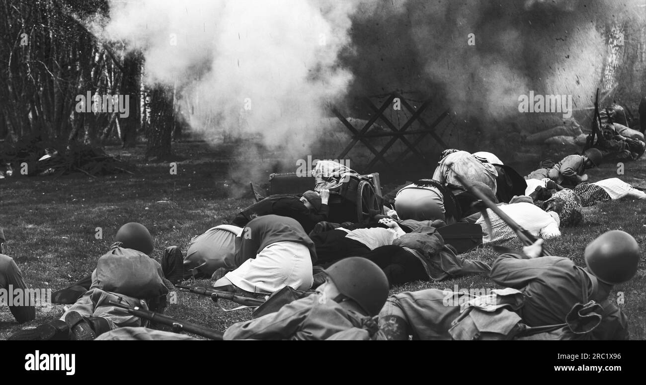 Les forces soviétiques russes du NKVD escortent des civils sous attaque aérienne. Uniforme des soldats soviétiques. Évacuation des civils. Noir et blanc Banque D'Images