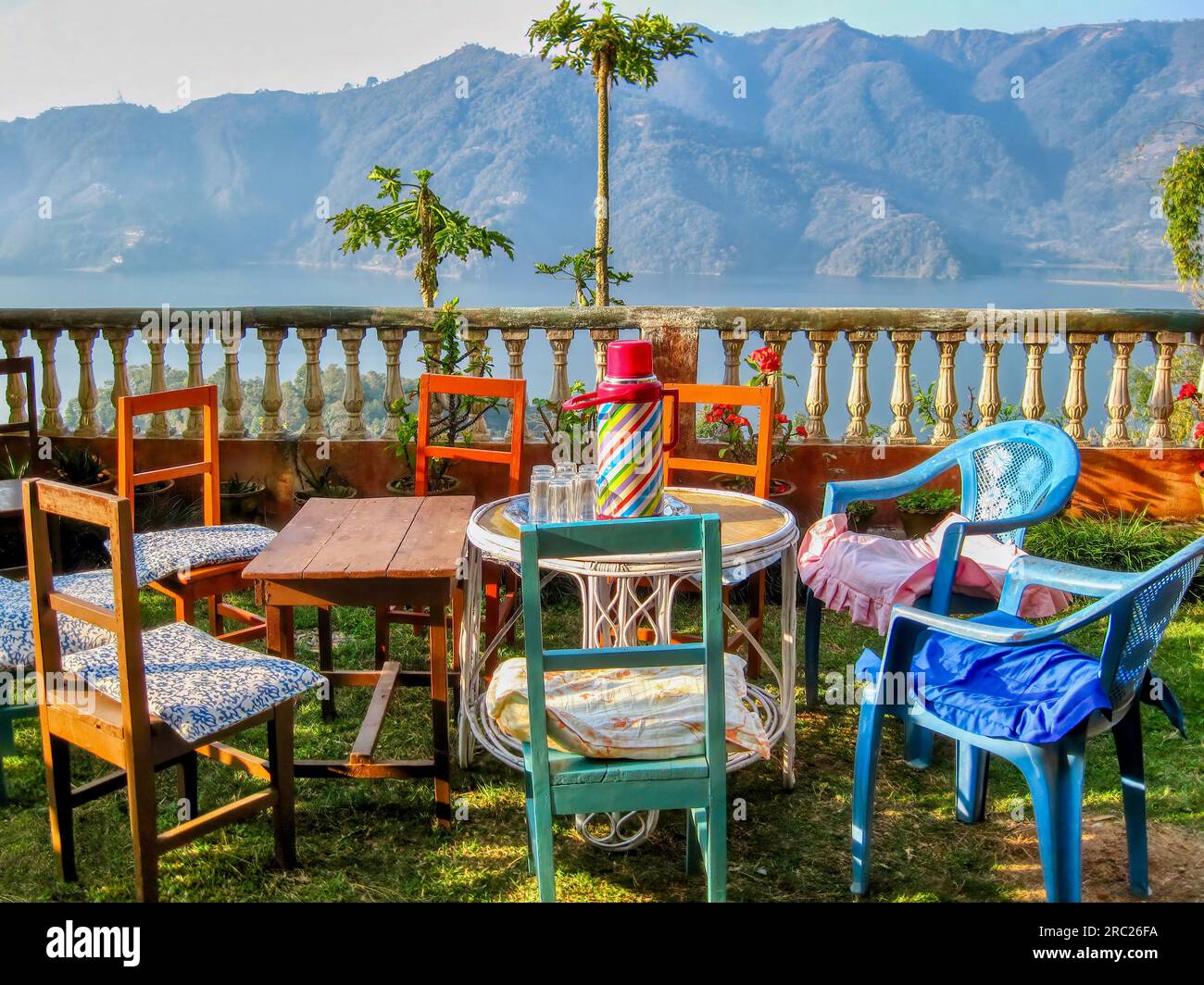 Un cadre rustique charmant, avec des tables et des chaises dépareillées pour une pause thé matinale, surplombant le lac Phewa à Pokhara, au Népal. Banque D'Images