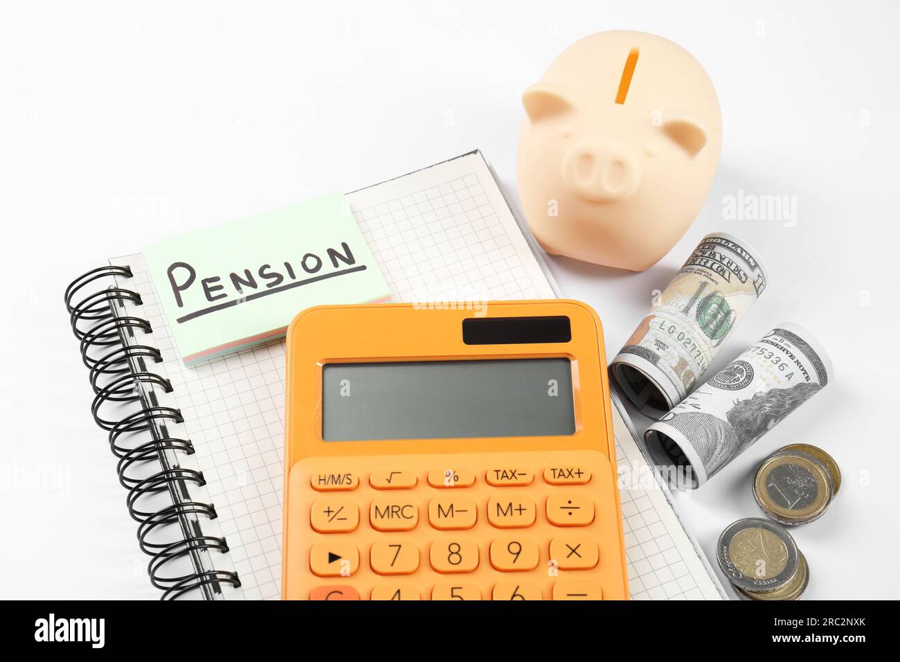 Calculatrice, tirelire et argent sur fond blanc. Concept de pension Banque D'Images
