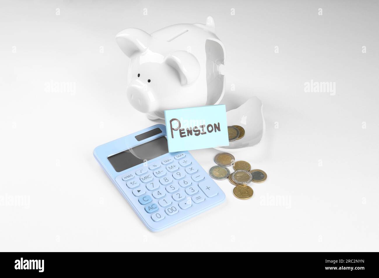 Calculatrice, carte avec le mot Pension, tirelire cassée et pièces de monnaie sur fond blanc. Concept de retraite Banque D'Images