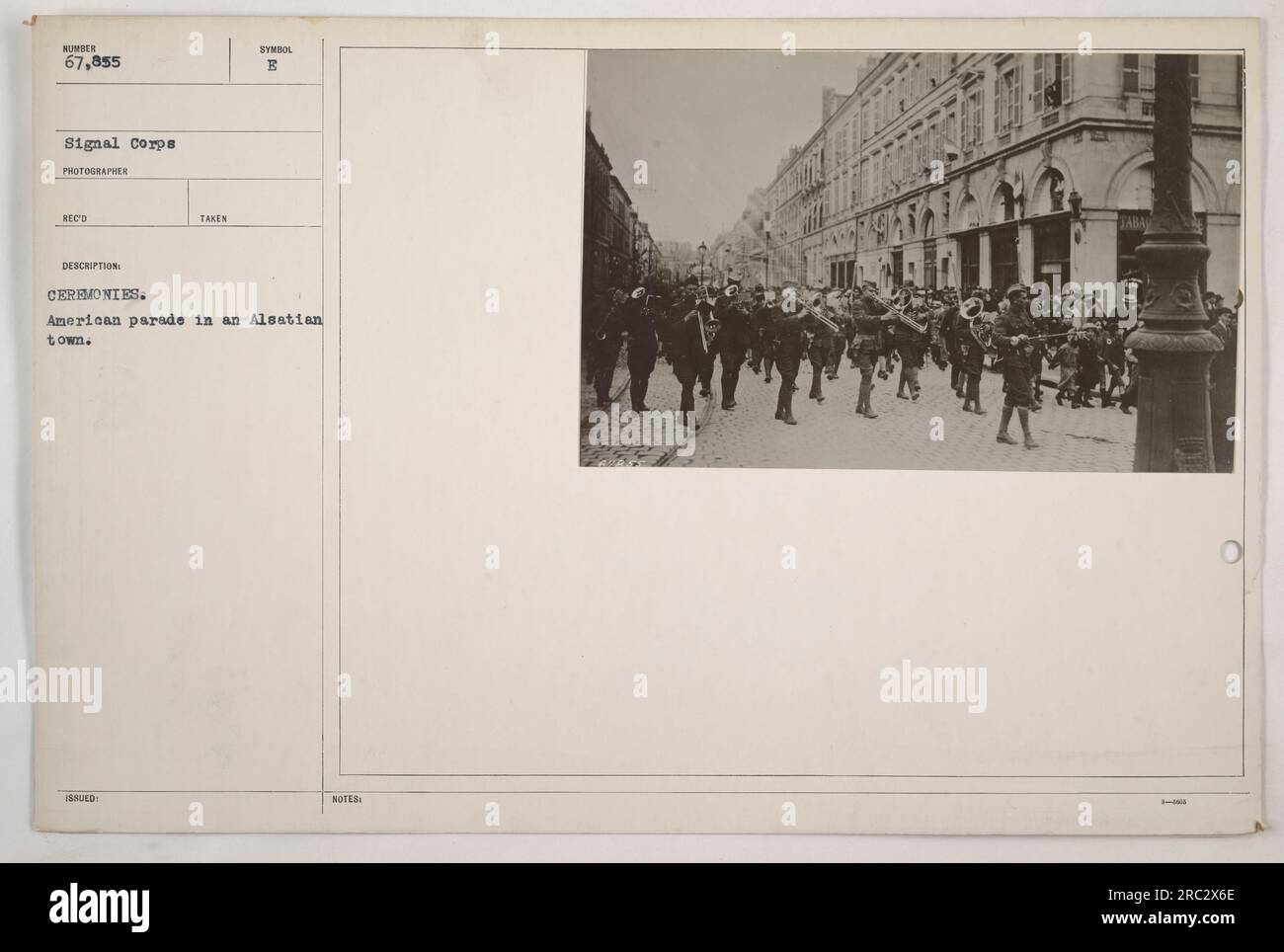 La photographie montre un défilé militaire américain qui se déroule dans une ville alsacienne pendant la première Guerre mondiale. La présence de soldats et de spectateurs indique un événement de célébration ou de commémoration. L'image a été prise par les photographes du signal corps 67 855, fournissant une documentation des activités militaires américaines pendant la guerre. La photographie est décrite comme étant prise sous le symbole B, qui peut faire référence à un événement ou à une mission spécifique. Le contexte et le but de la cérémonie ne sont pas précisés dans les informations disponibles. Banque D'Images