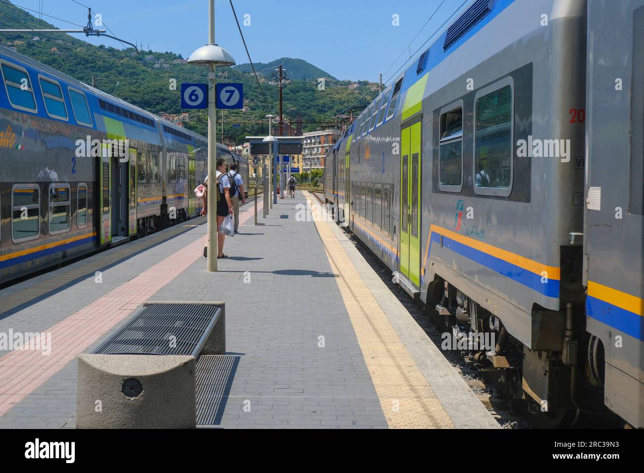 Juin 2023 la Spezia, Italie : gare, passagers avec valises et trains rapides à travers le paysage montagneux Banque D'Images