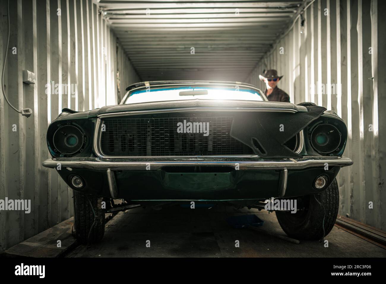 Classic American muscle car endommagé à l'intérieur d'un conteneur de cargaison d'expédition. Thème de restauration des voitures anciennes Banque D'Images