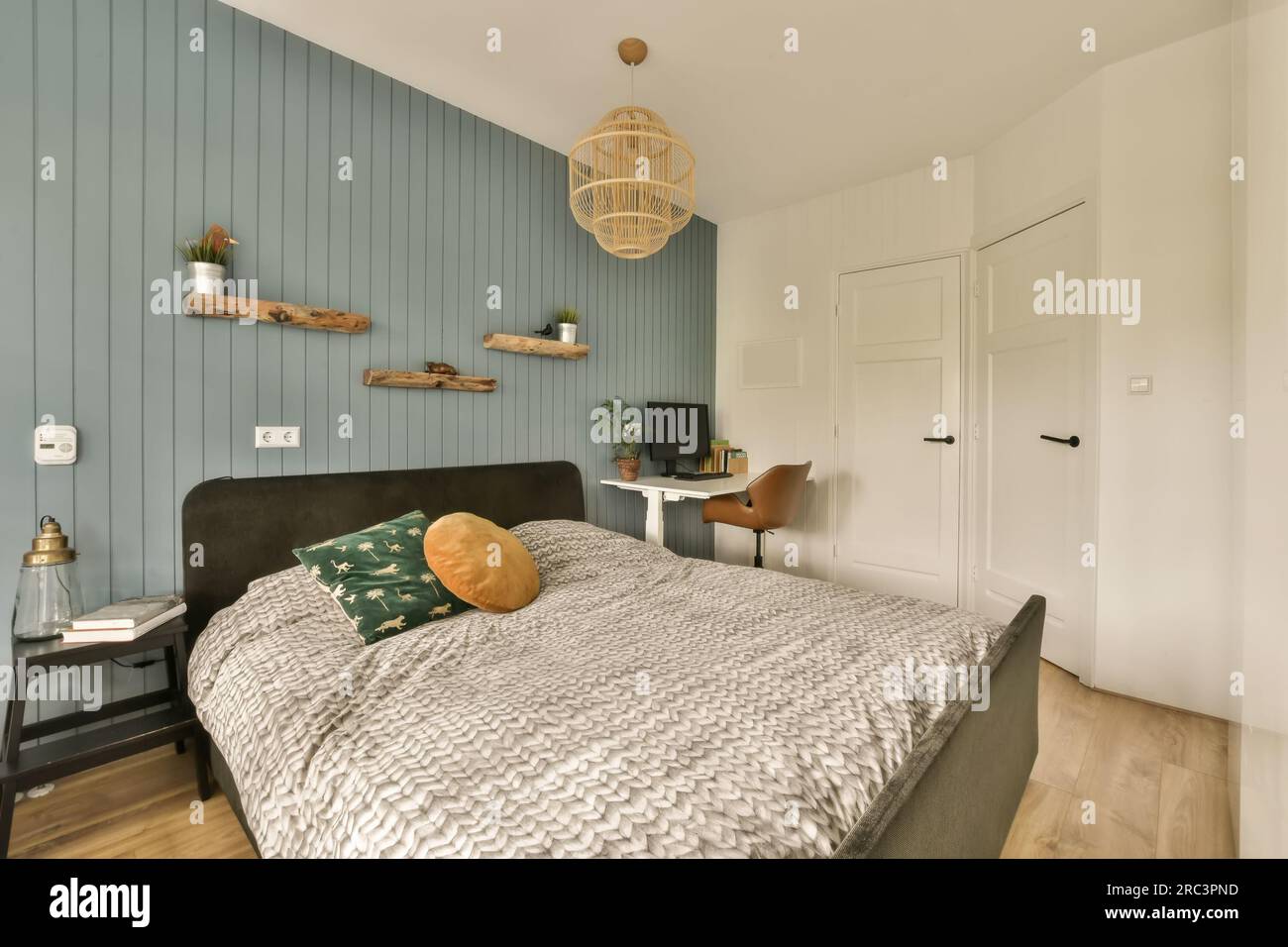 une chambre avec parquet et papiers peints bleus sur les murs, le lit est composé de velours noir Banque D'Images