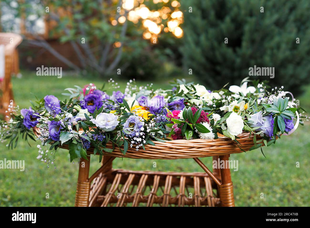 couronne florale d'eustoma blanc et lilas sur la table en osier dans le café Banque D'Images