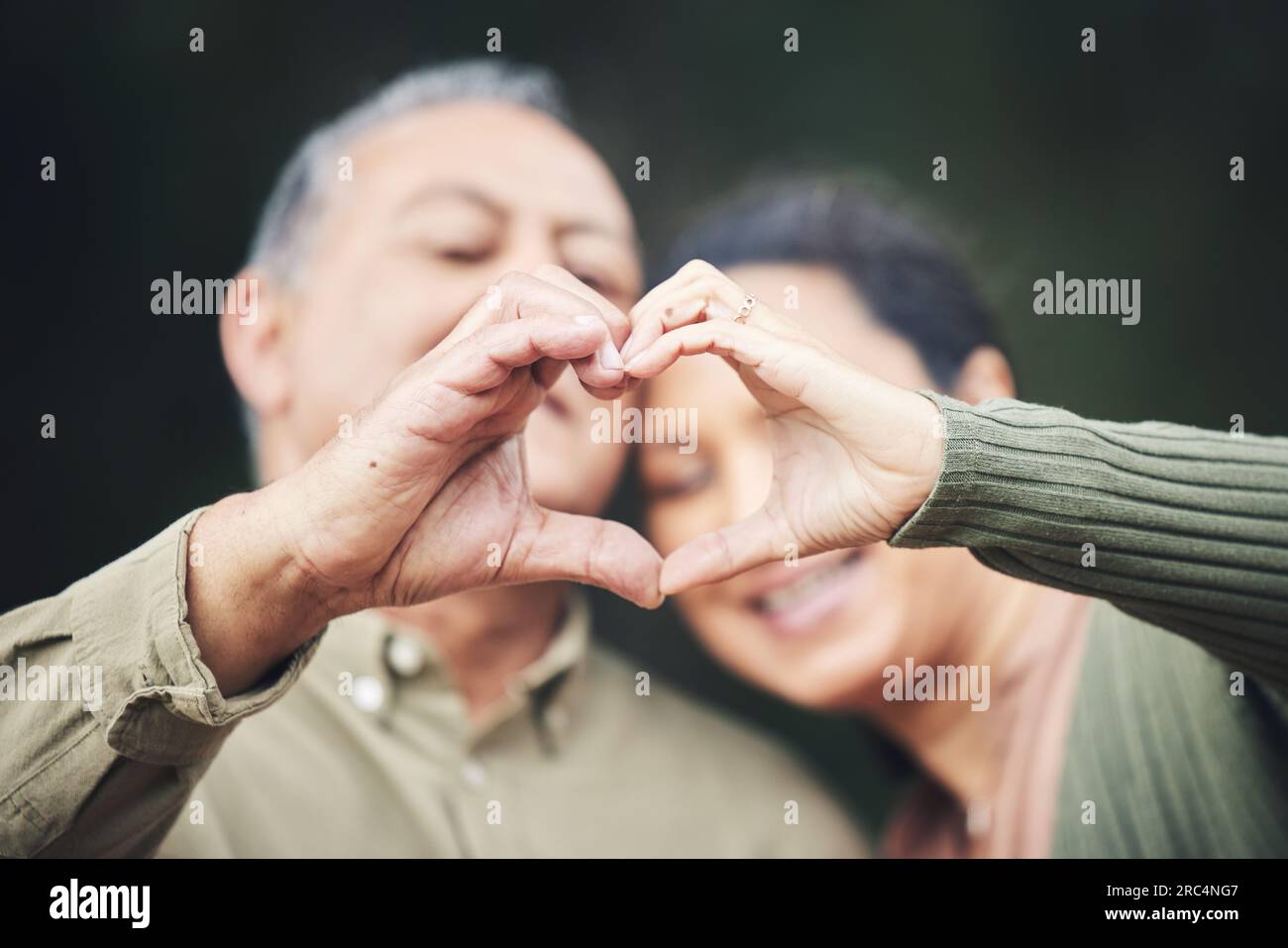 Cœur, mains et un couple de personnes âgées dans une maison pour l'amour, les soins et montrer un emoji ensemble. Heureux, confiance et un homme et une femme âgés avec un geste pour Banque D'Images