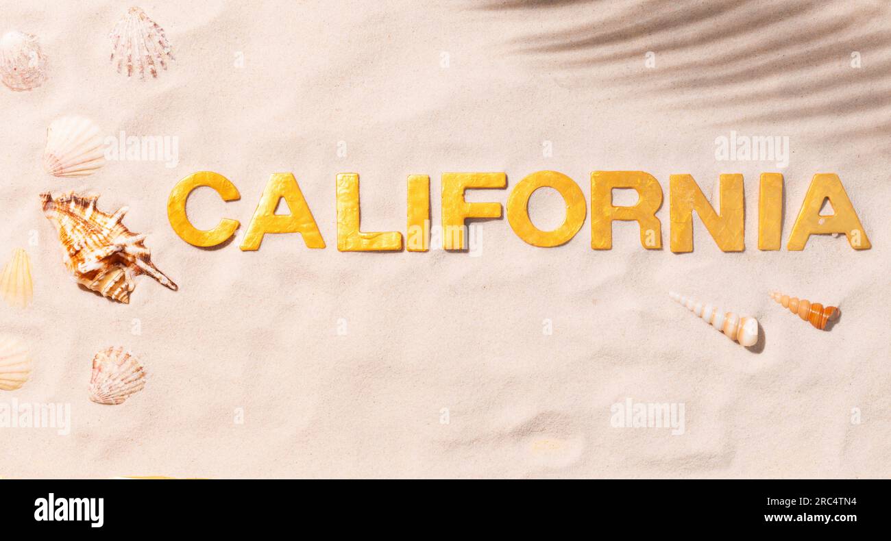 Californie - texte en sable blanc avec coquillages. Concept de vacances à la plage Banque D'Images