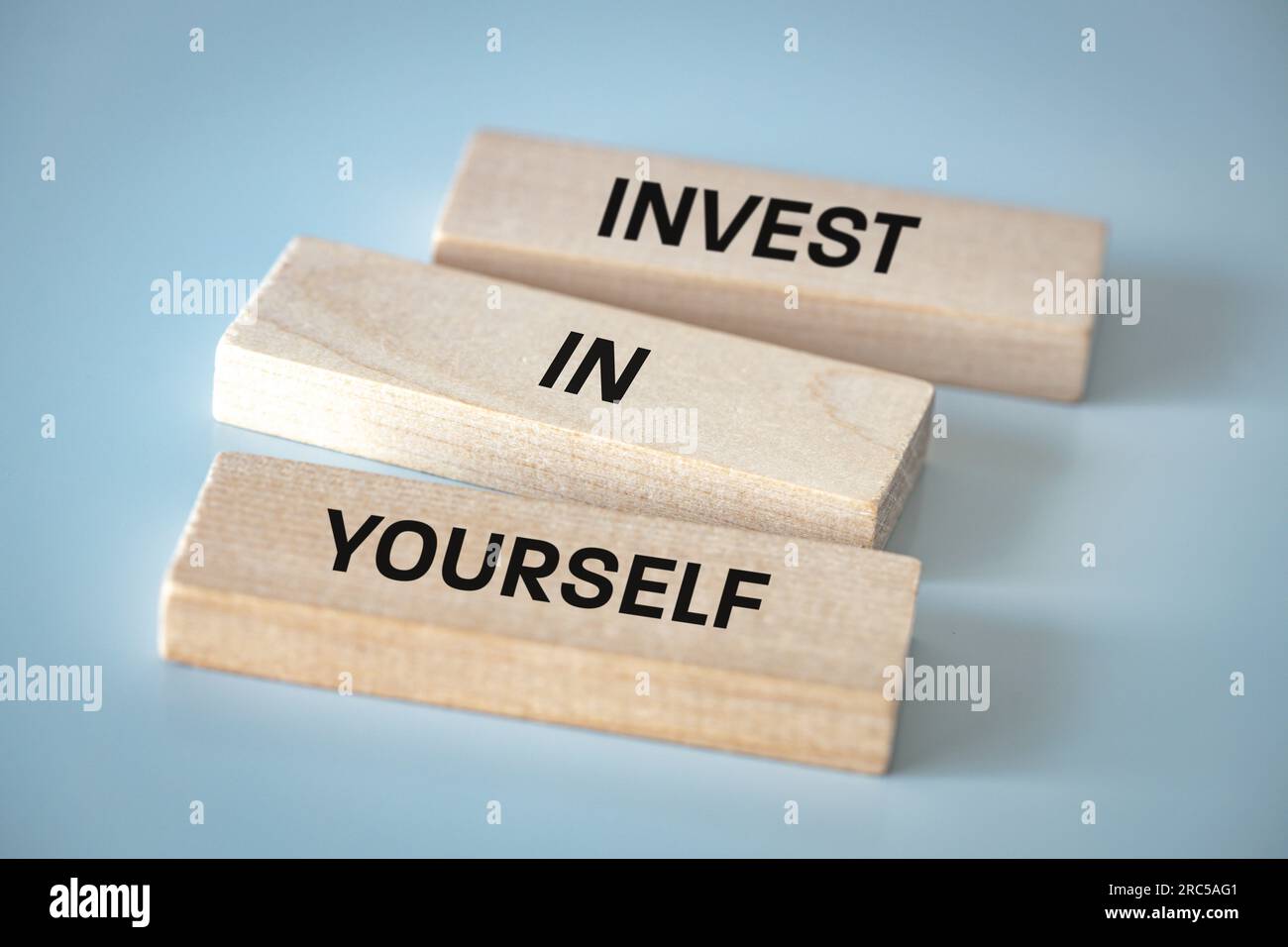 Investissez en vous-même, les blocs de bois forment un slogan, investissez en vous-même, le concept de développement et de réalisation de soi dans la vie et les affaires, belle l Banque D'Images