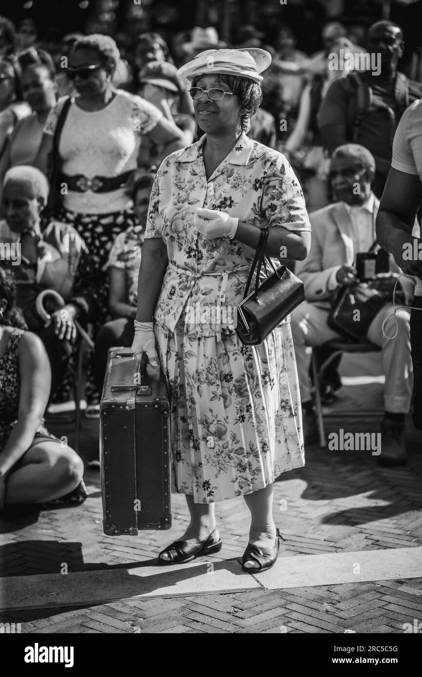 Une image en noir et blanc d'une dame habillée en migrante de la 'génération Windrush' le jour de Windrush et son 75e anniversaire. Banque D'Images