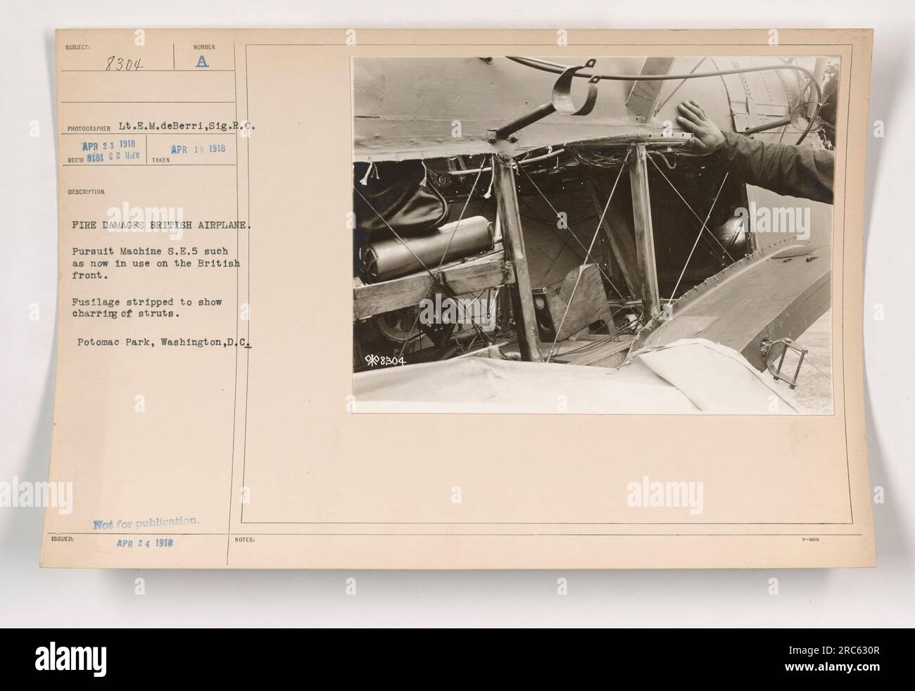 Légende : le lieutenant E.M. deBerri du 81e régiment du Camp dix examine une machine de poursuite britannique 8.E.5 qui a été endommagée par un incendie. Le fuselage a été dépouillé pour révéler les jambes carbonisées. La photographie a été prise le 23 avril 1918 à Potomac Park, Washington, DC Non destiné à la publication. Notes supplémentaires : 908504. Banque D'Images