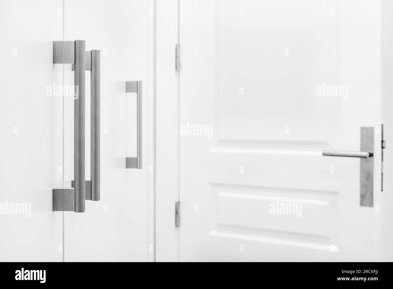 Le métal texturé tire sur les portes d'armoire en bois laqué blanc dans un walk-in Banque D'Images