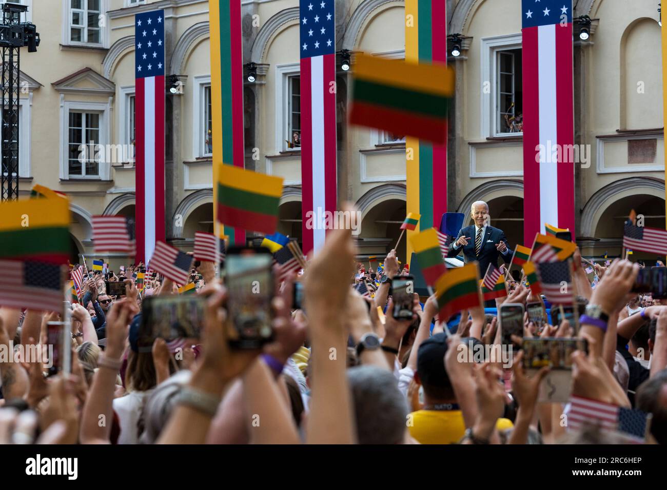 Vilnius, Lituanie. 12 juillet 2023. Les gens brandissent les drapeaux de l'Amérique et de la Lituanie en regardant le président américain Joe Biden prononcer un discours devant les nations lituanienne et ukrainienne à l'Université de Vilnius à la suite du sommet de l'OTAN, le 12 juillet 2023 à Vilnius, en Lituanie. Une foule estimée à 10 000 personnes agite des drapeaux lituaniens, américains et ukrainiens et applaudit le président. Crédit : Adam Schultz/White House photo/Alamy Live News Banque D'Images